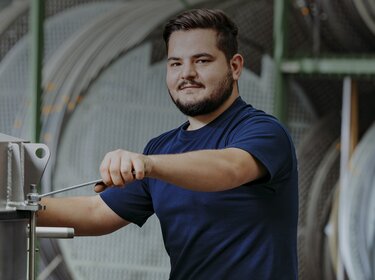 Empleados de Allgaier trabajando en una máquina de cribado en una sala de producción | © Allgaier Process Technology 2022