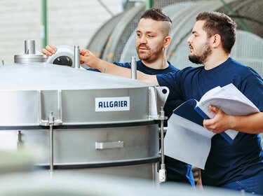 allgaier mitarbeiter arbeiten an einer vibrations-rundsiebmaschine | © vibrations-rundsiebmaschinen in einer produktionshalle nahansicht