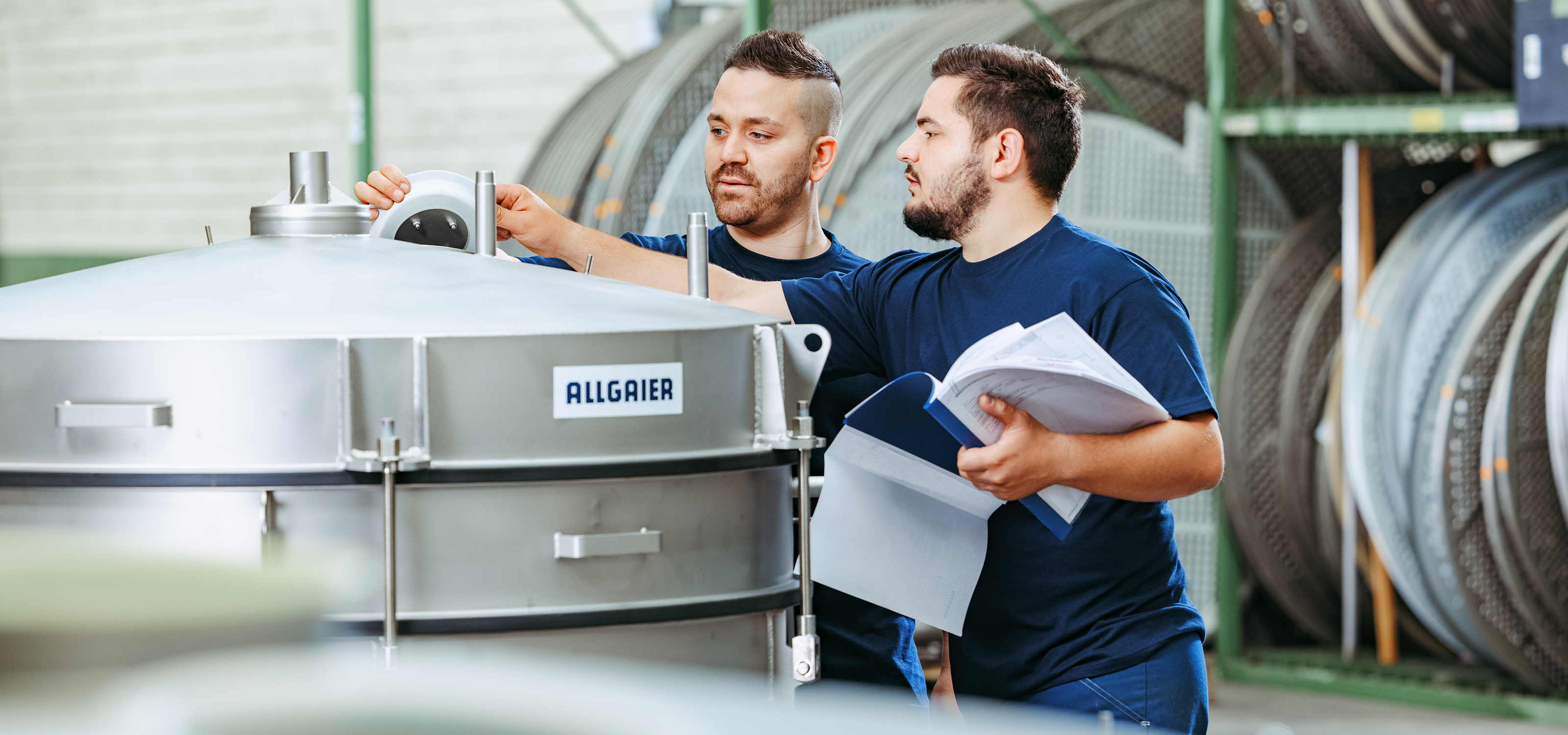 © vibrations-rundsiebmaschinen in einer produktionshalle nahansicht allgaier mitarbeiter arbeiten an einer vibrations-rundsiebmaschine | © vibrations-rundsiebmaschinen in einer produktionshalle nahansicht