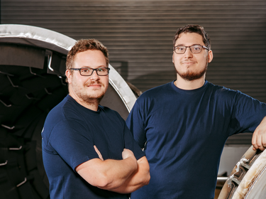 dos hombres junto a un tambor de secado en una sala de producción | © Allgaier Process Technology 2022