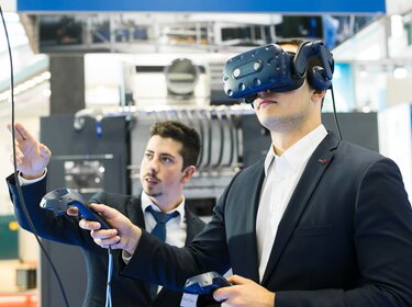 un employé d'allgaier avec des lunettes vr lors d'un salon professionnel | © Allgaier Process Technology 2022