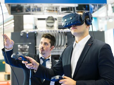 Allgaier employee with VR glasses at a trade fair | © Allgaier Process Technology 2022